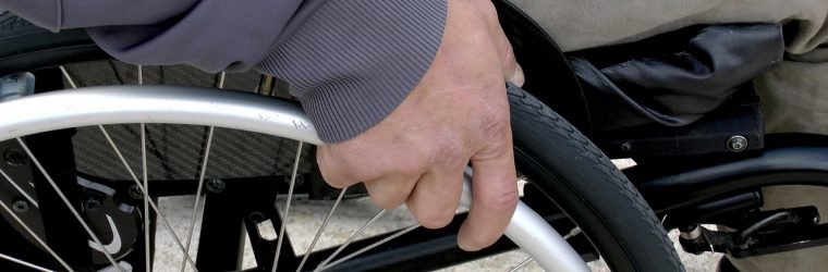 Persona empujando una silla de ruedas